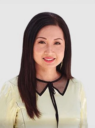 Dentist Tran Dang In Front Of Grey Background Smiling