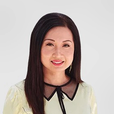 Dentist Tran Dang Smiling In Front Of Grey Background